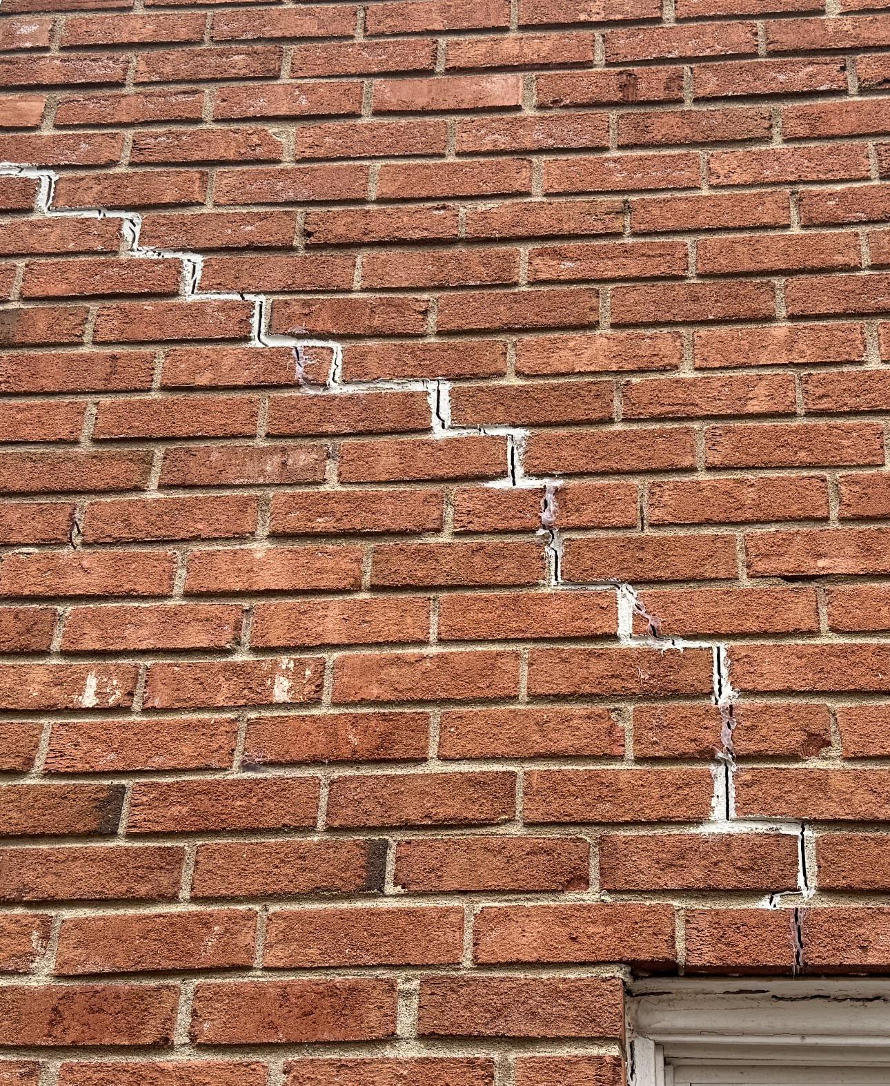 Stair-step cracks in brick mortar joints - common foundation damage warning sign in Kyle TX homes